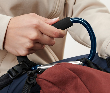 Kişi, kahverengi bir sırt çantasına takılı mavi bir 2 Adet XXL Karabina Kanca tutuyor.