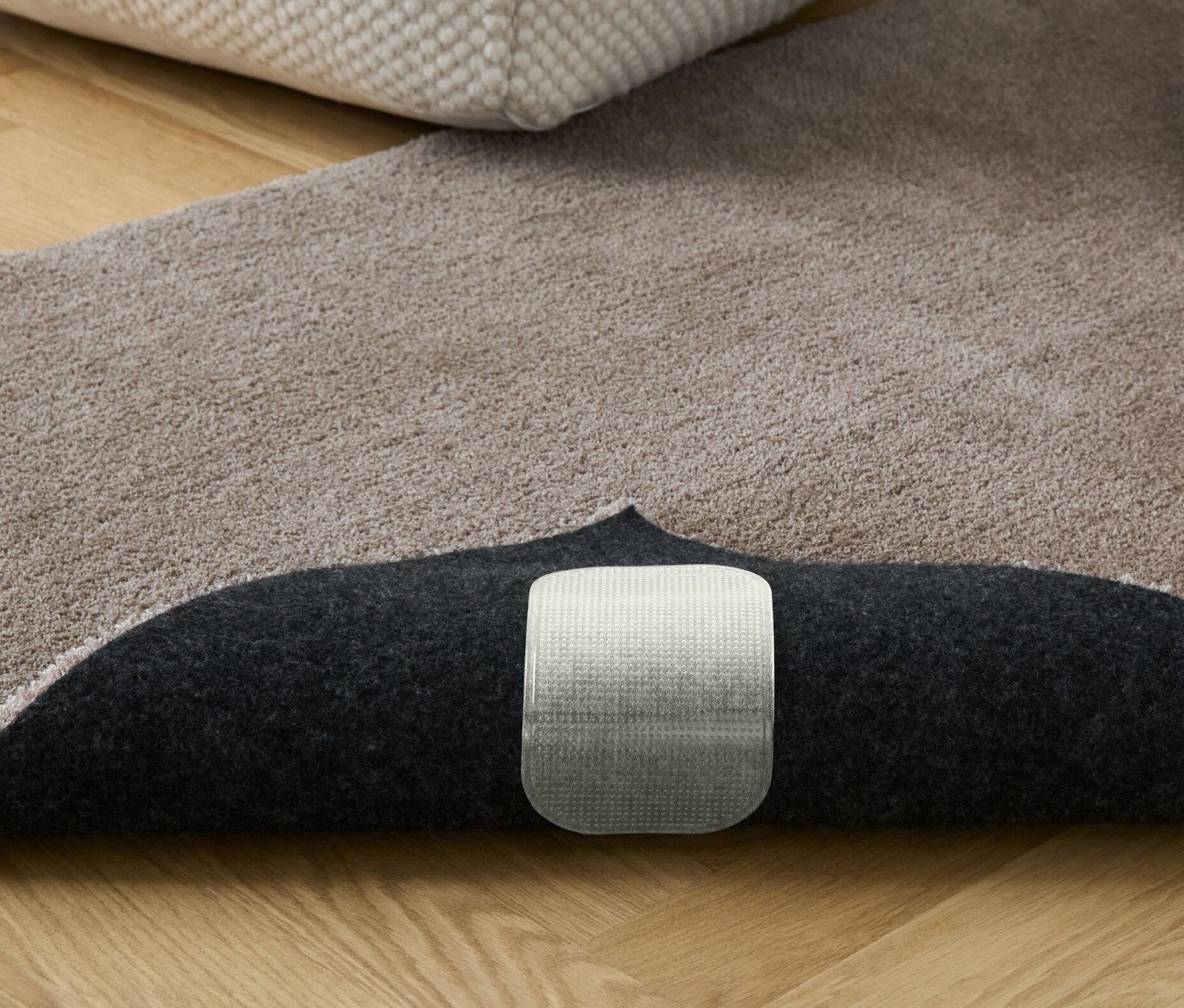 Kitapların ve pufun bulunduğu bej halı. 4 Adet Halı Kaydırmaz görünür.