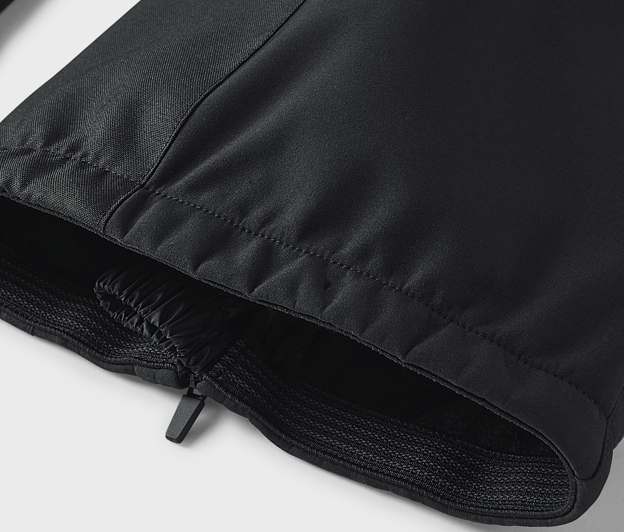 Siyah pantolonun fermuarlı ve lastikli kenarının detayı.