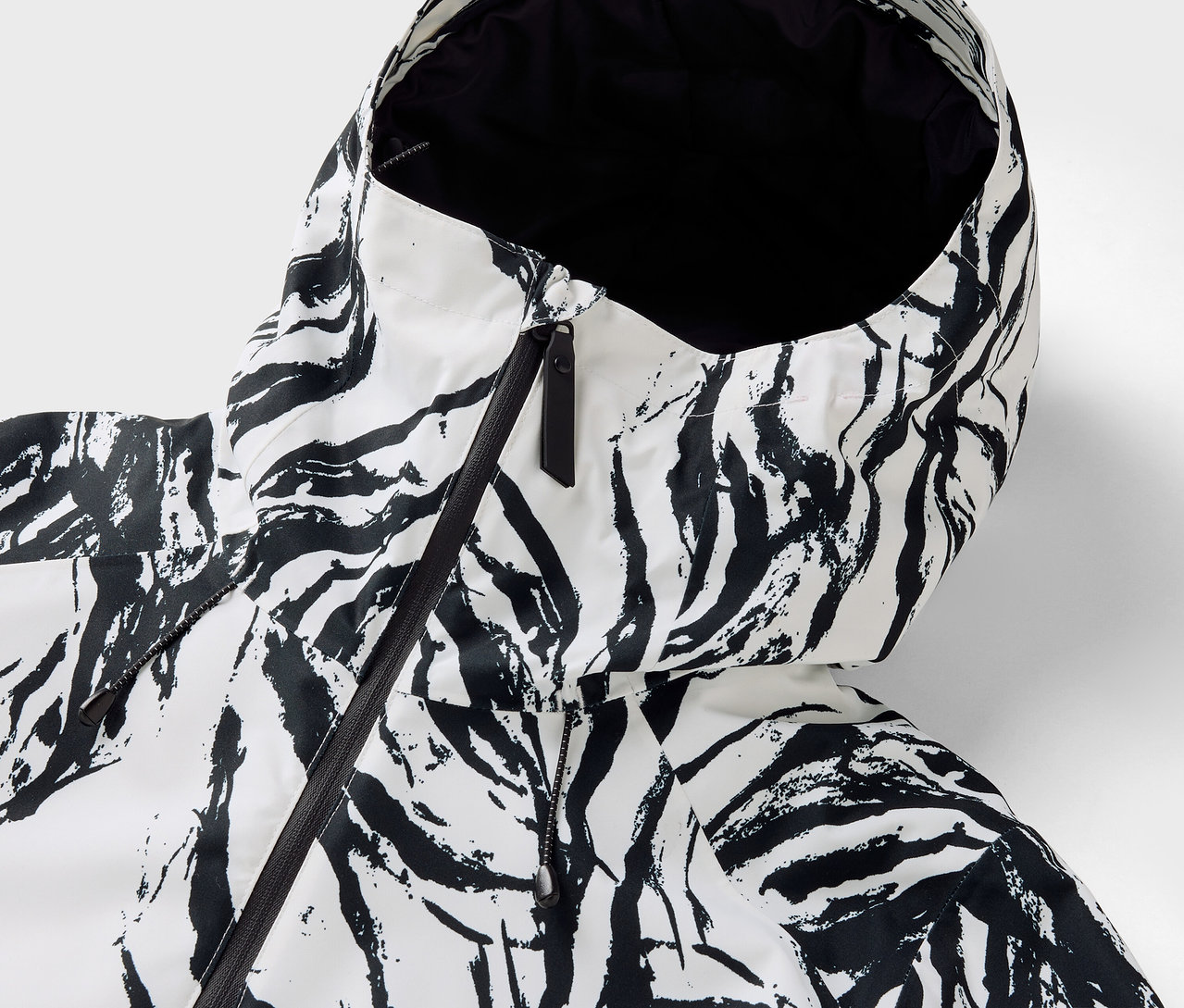 Zebra deseni ve siyah fermuarlı bir ceket kapüşonunun yakın çekimi.