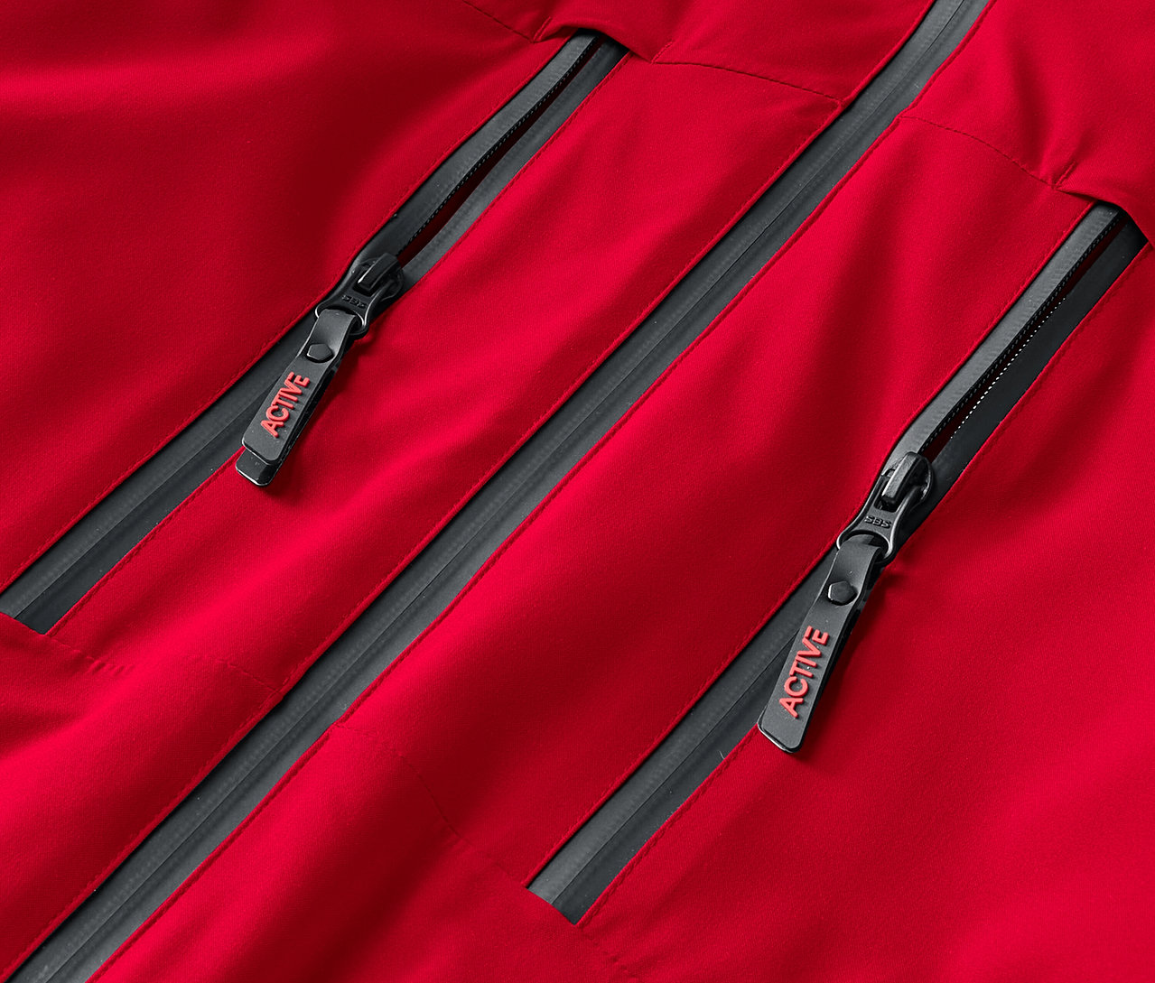 Üzerinde ACTIVE yazısı olan iki gri fermuarlı kırmızı bir ceketin yakın çekimi.