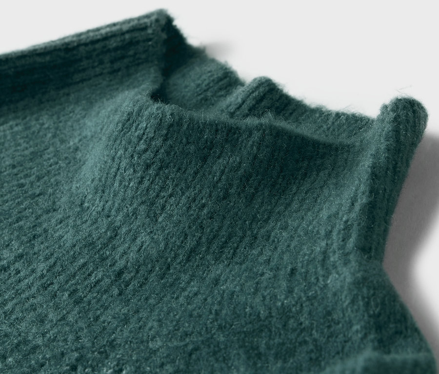 Yeşil örgü balıkçı yaka kazaktan detaylı bir çekim.