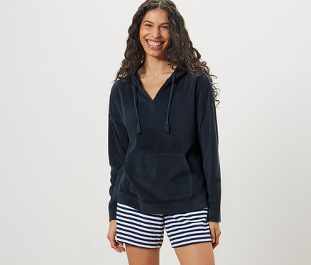 Kadın Havlu Hoodie ve çizgili şort giyiyor.