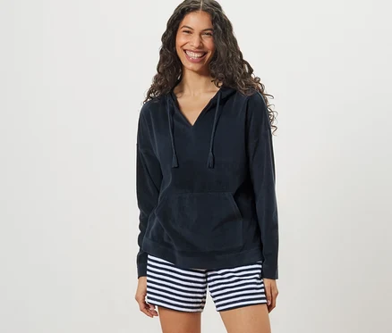 Kadın Havlu Hoodie ve çizgili şort giyiyor.