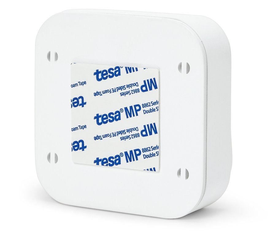 Dört delikli ve Tesa MP yapışkan şeritli beyaz bir kutunun arkası.