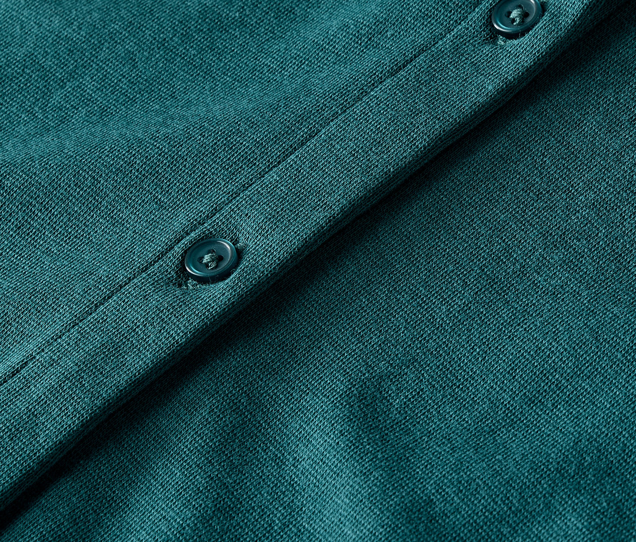 Düğmeli, yeşil örgü hırkanın yakın çekimi.