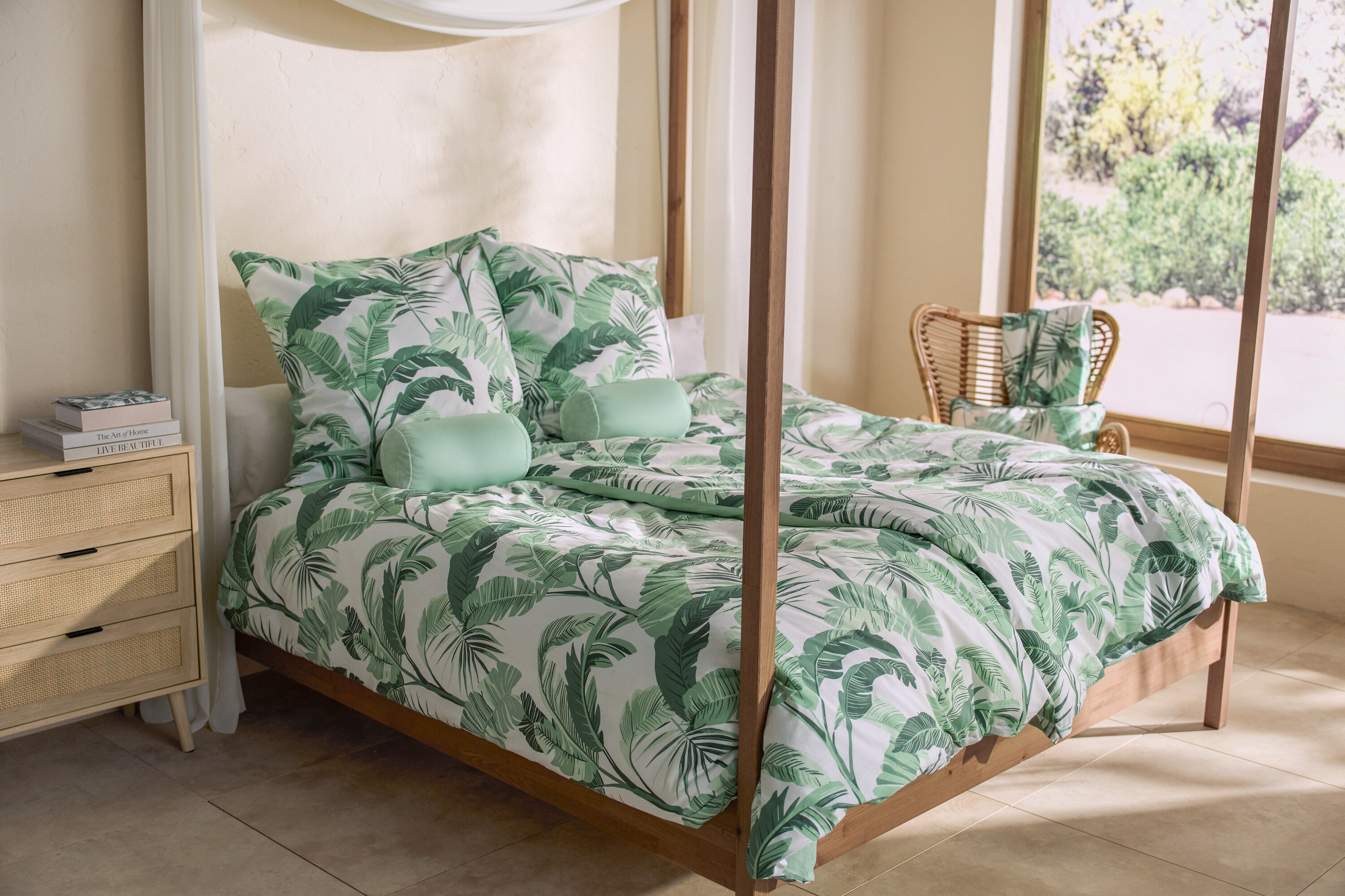 Palmiye desenli renforcé nevresim takımı, iki adet jarse yastık kılıfı ve bir adet rahatlama yastığıyla birlikte dört direkli bir yatak. Yatağın yanında bir komodin ve 3 adet not defteri bulunmaktadır.