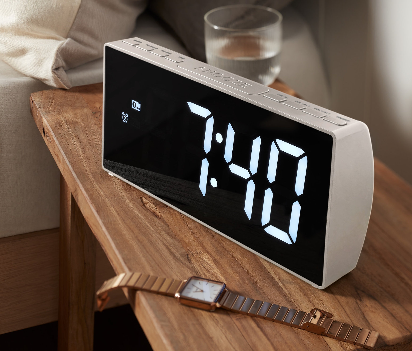 Bir XXL Radyolu Çalar Saat, bir yatağın yanındaki ahşap bir komodinin üzerinde duruyor. Ekranda saat 7:40 yazıyor.