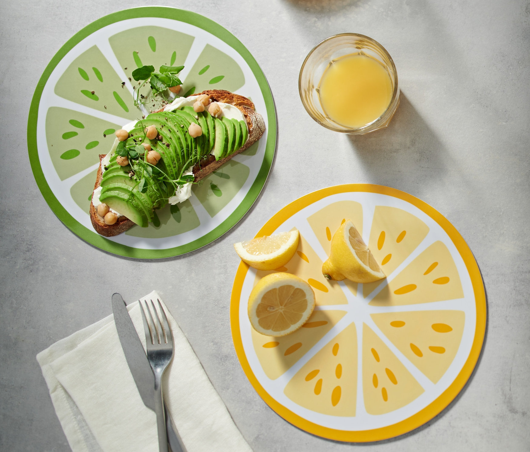 Yeşil 2 Frühstücksbretter üzerinde avokado tost, yanında bir sürahi ve bir bardak meyve suyu.