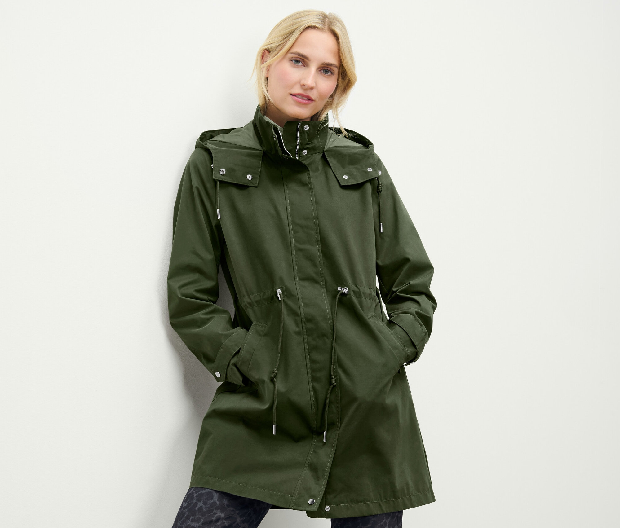 Kadın yeşil kapüşonlu parka giyiyor