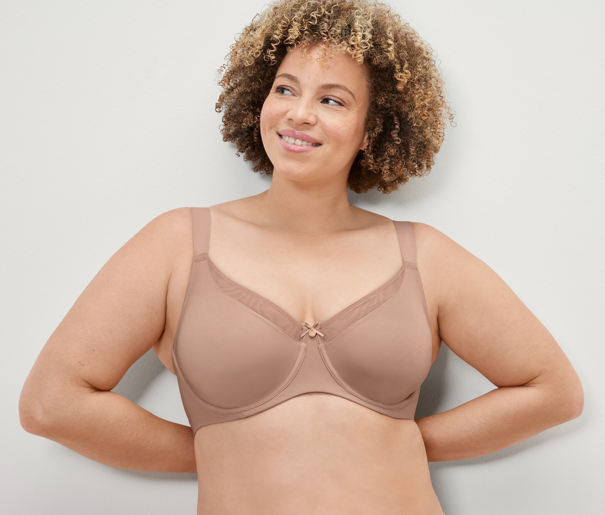 Kadın, bej Toparlayıcı Sütyen giyiyor.
