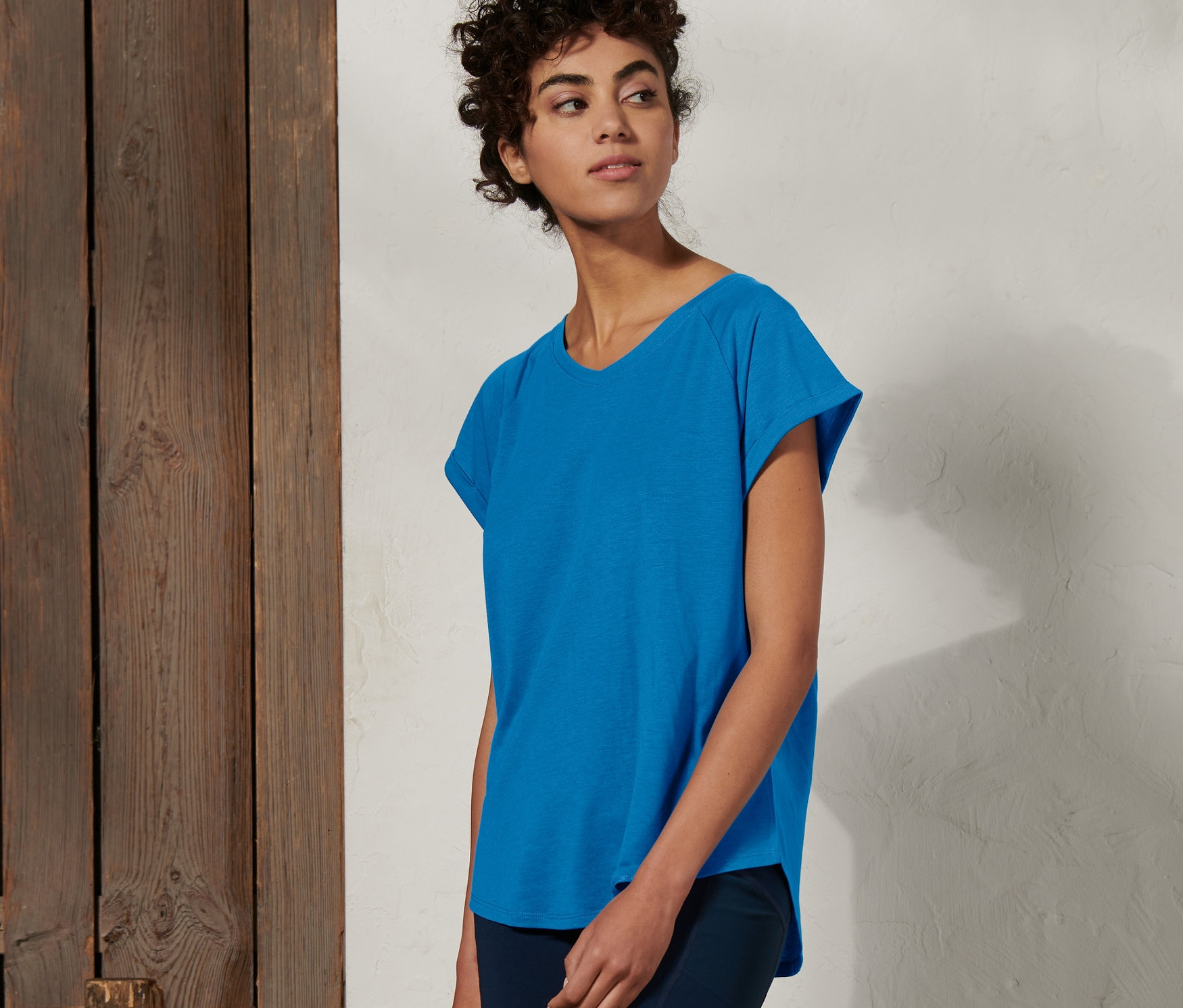 Kadın açık mavi fonksiyonel tişört ve koyu mavi şort giyiyor.