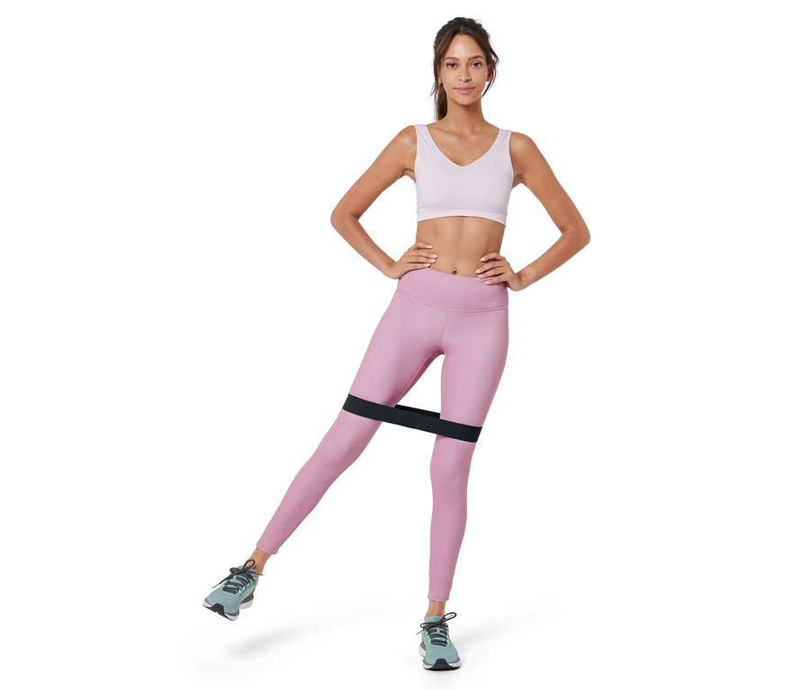 Kadın bacaklarında siyah bir antrenman bandıyla (3 adet) egzersiz yapıyor.