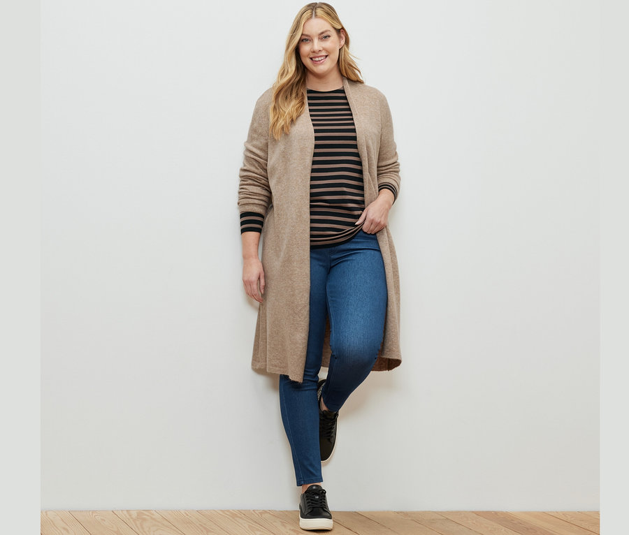 Kadın Jeggings, Çizgili Uzun Kollu Tişört, Siyah-Kahverengi ve Düğmesiz Uzun Hırka ile poz veriyor.