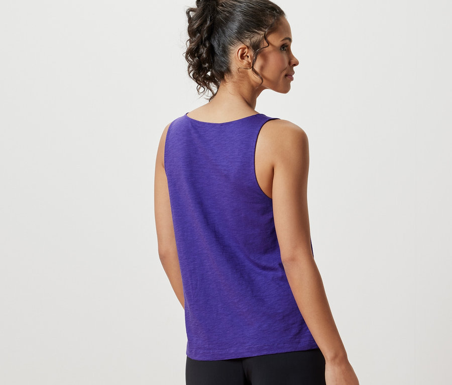 Arkadan görünen bir kadın mor modal karışımlı bir bluz ve siyah pantolon giyiyor.