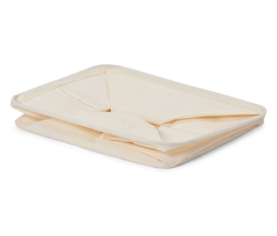 Katlanmış, krem rengi kumaş saklama kutusu.