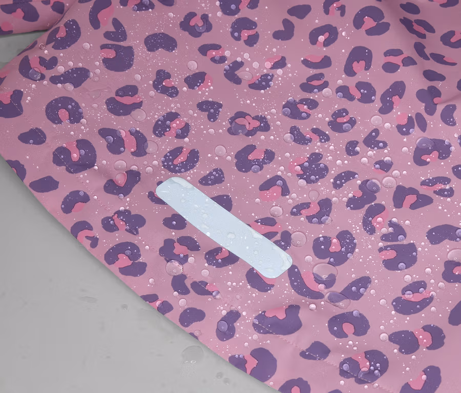 Pembe, mor leopar desenli, su damlalı ve beyaz reflektörlü kumaşın yakın çekimi.