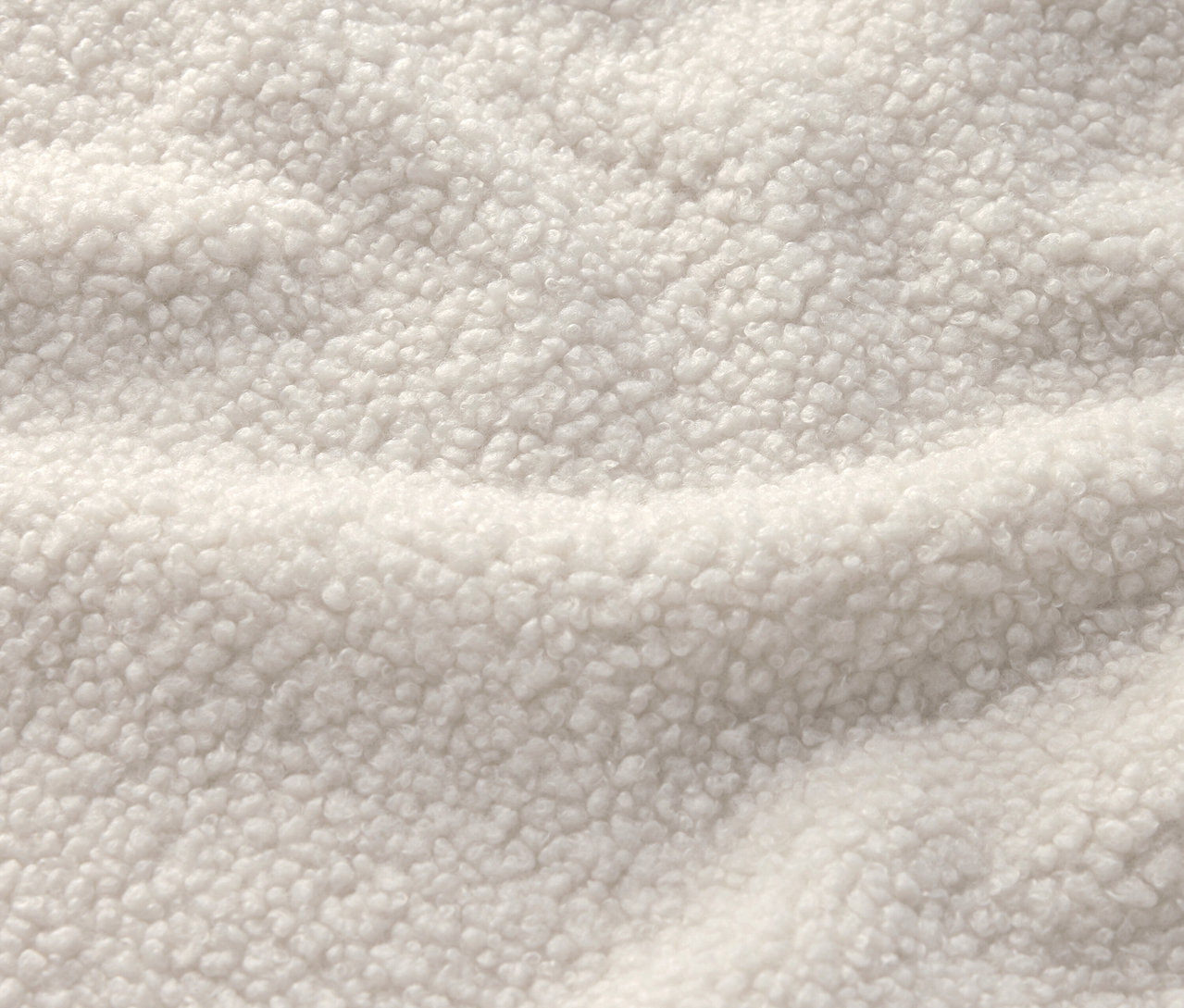 Sherpa dokulu, krem beyazı bir kumaşın yakın çekimi.