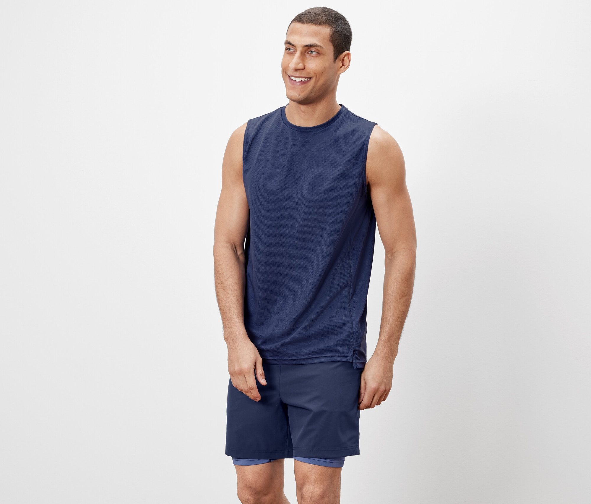 Adam bir tanktop ve şort giyiyor.