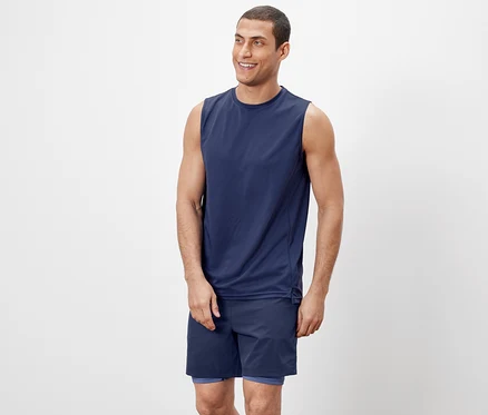 Adam bir tanktop ve şort giyiyor.