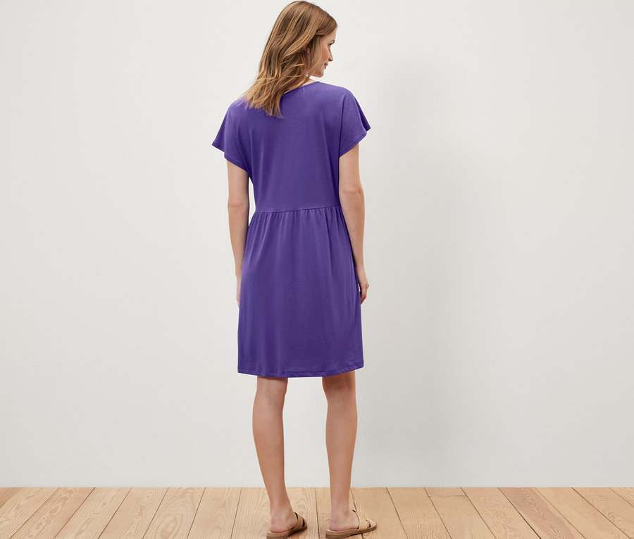 Kadın mor, jarse elbise giyiyor.