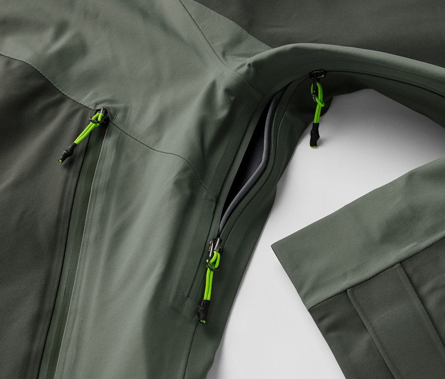 Açık cepli ve neon yeşili fermuar detaylı 3 Katlı Outdoor Montun yakın çekim görüntüsü.
