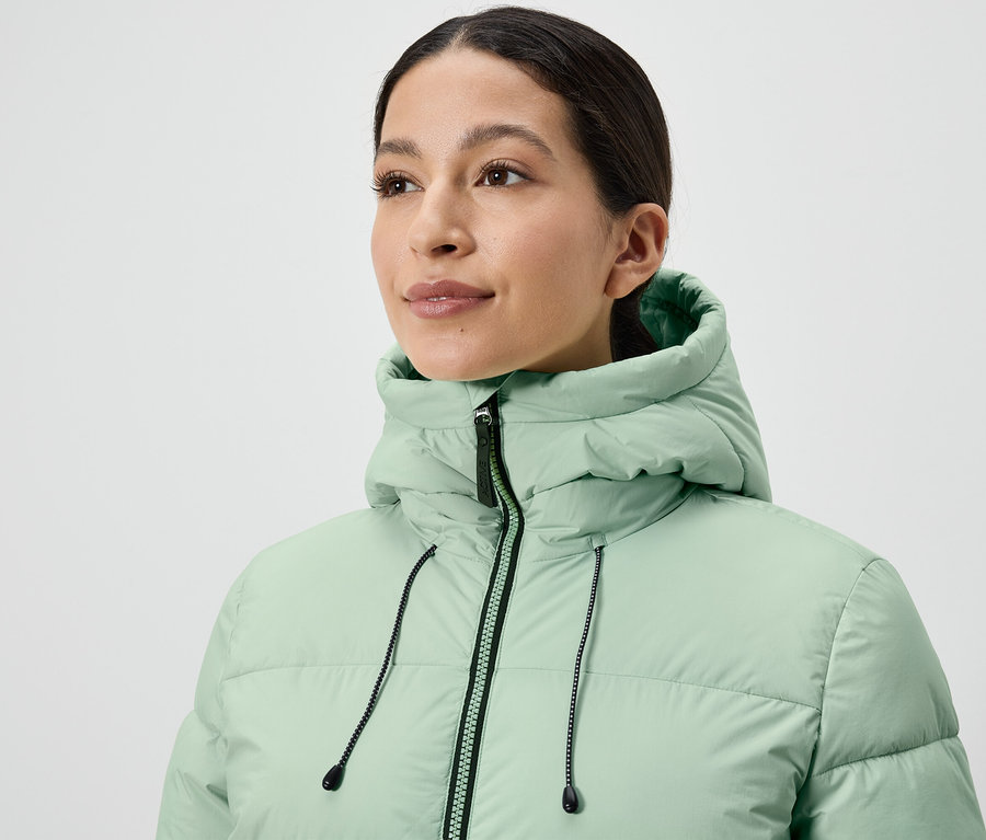 Açık yeşil şişme montlu kadın.