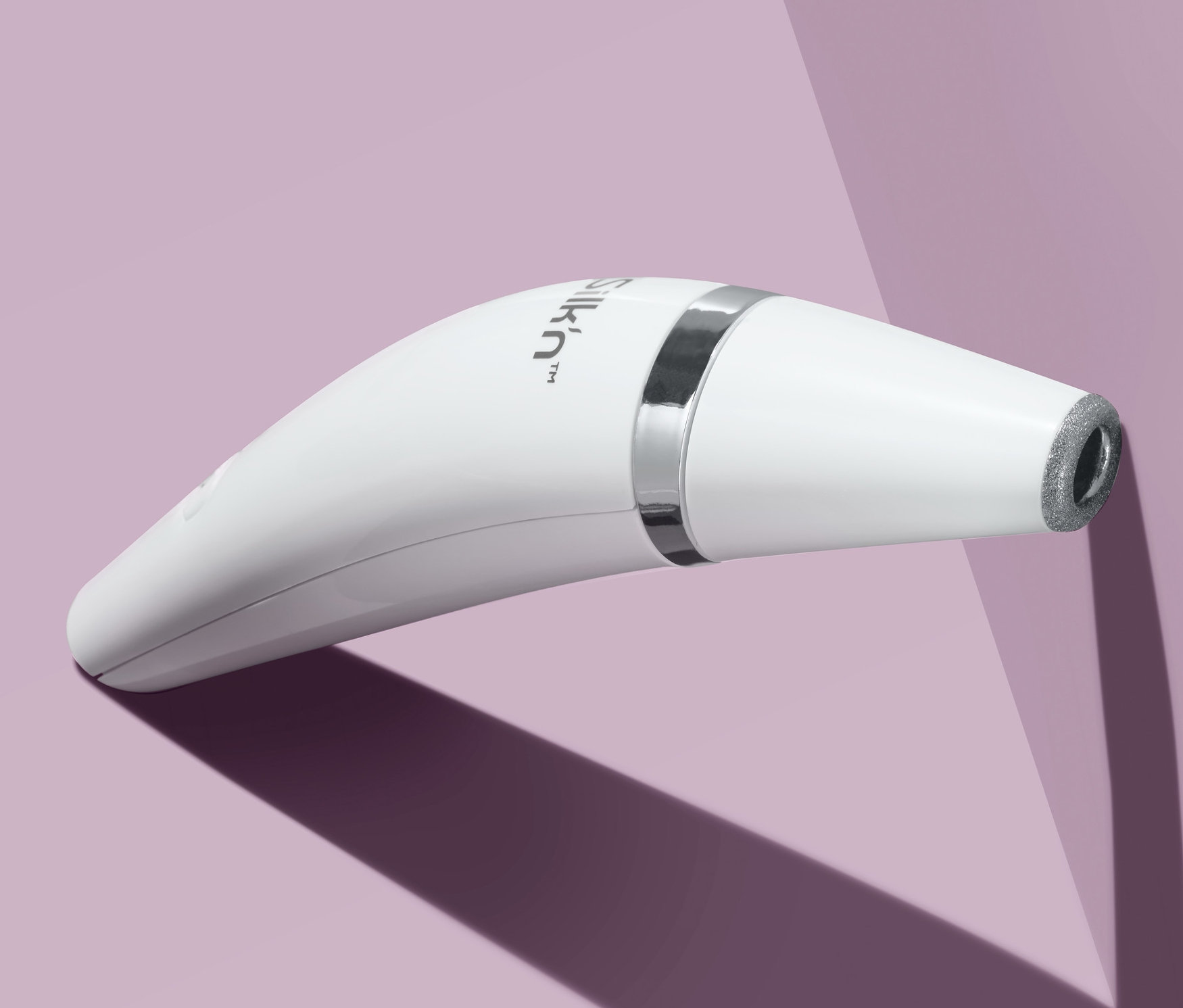 Lila bir arka plan üzerinde beyaz bir Silk’n® ReVit Essential Mikro Dermabrazyon Aleti yakın çekimi.