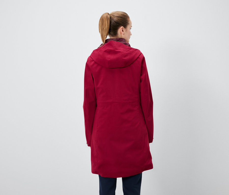 Atkuyruğu saçlı, kırmızı kapüşonlu mont ve lacivert pantolon giyen bir kadının arka görüntüsü..