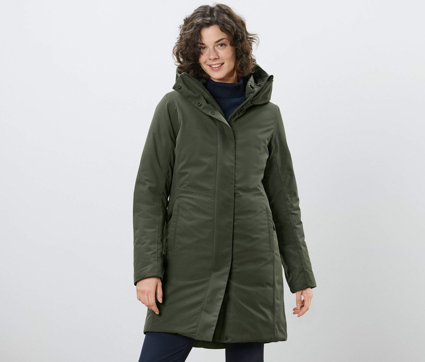 Kadın haki termal manto ile poz veriyor.