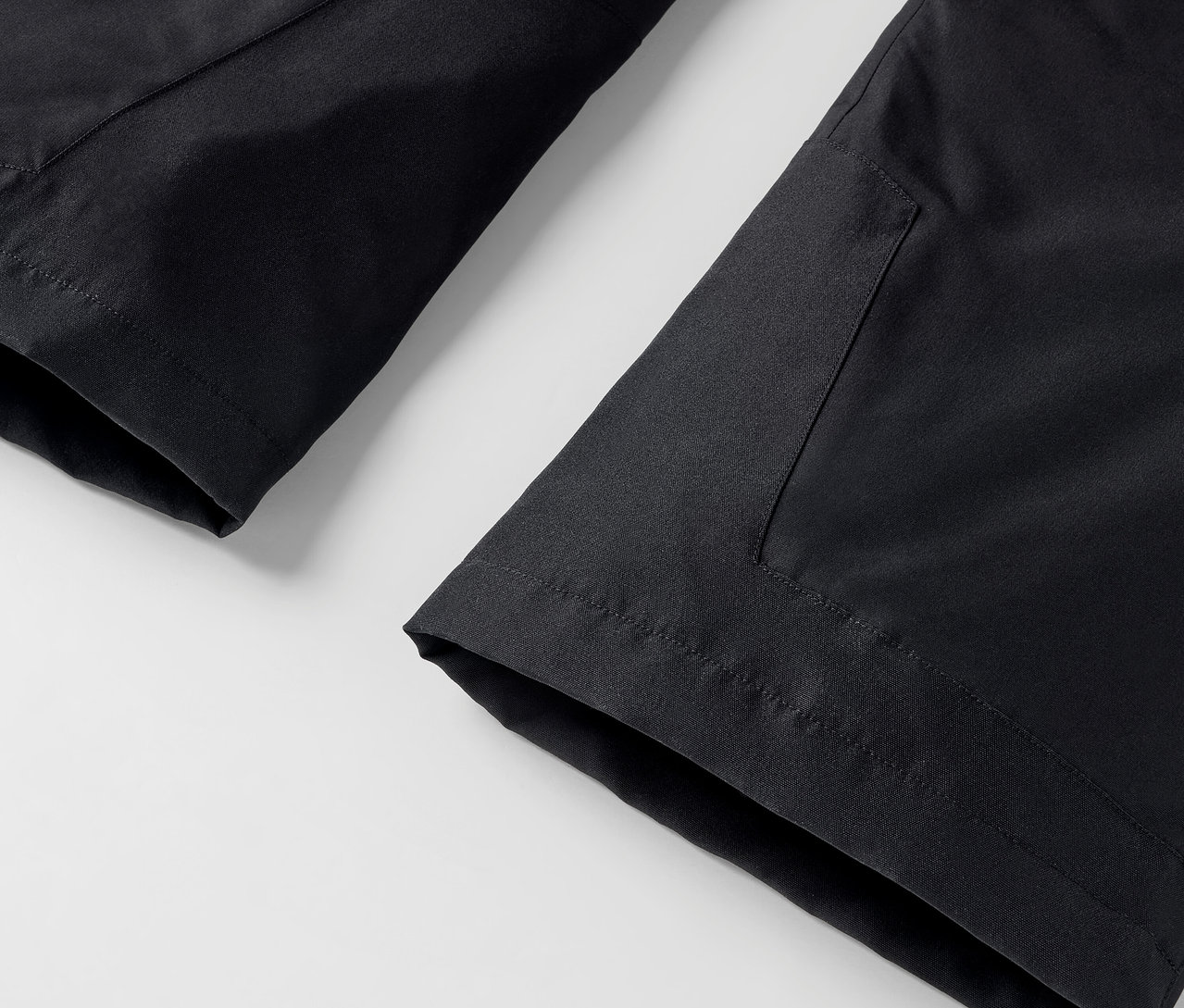 Beyaz zemin üzerinde cepli siyah pantolon detayı.