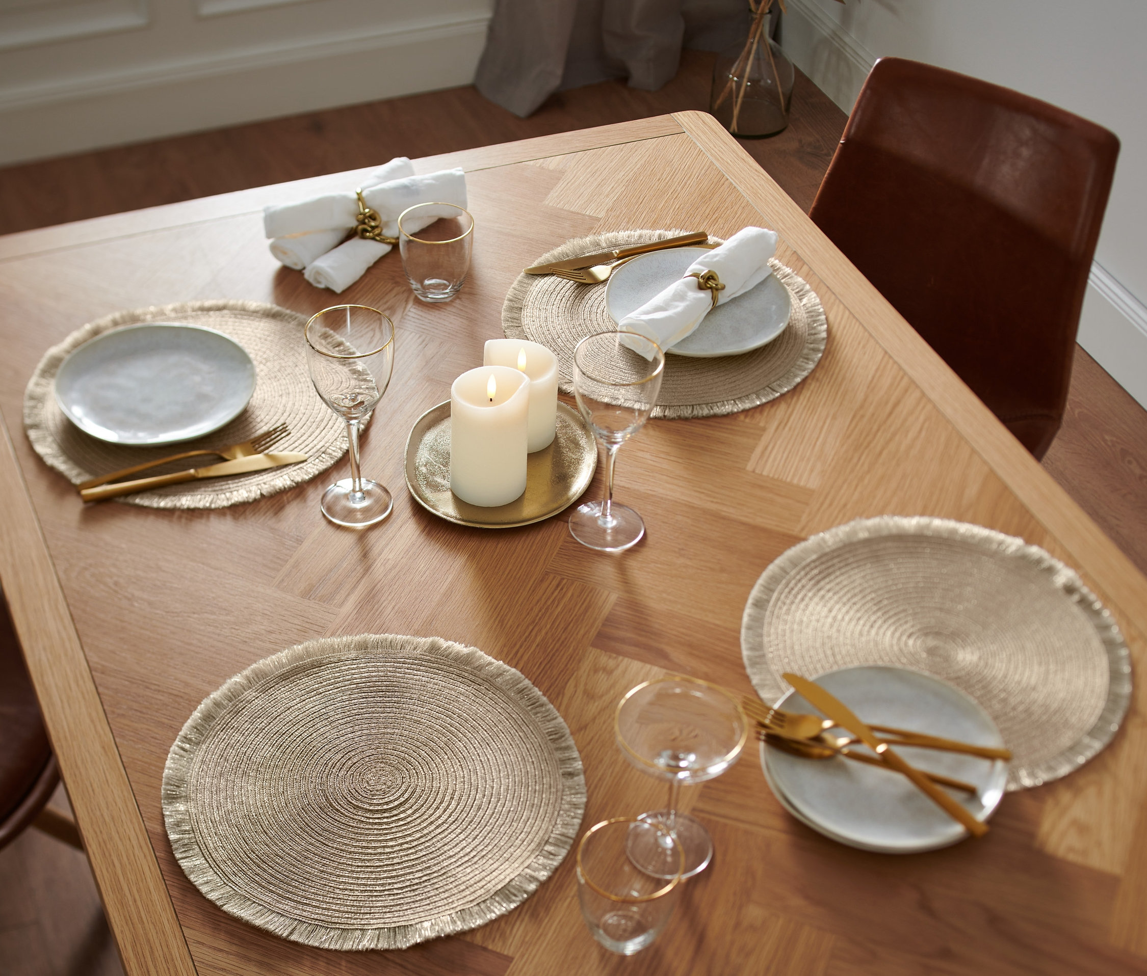 Ahşap bir masa üzerinde dört adet altın rengi Amerikan servisi bulunmaktadır.