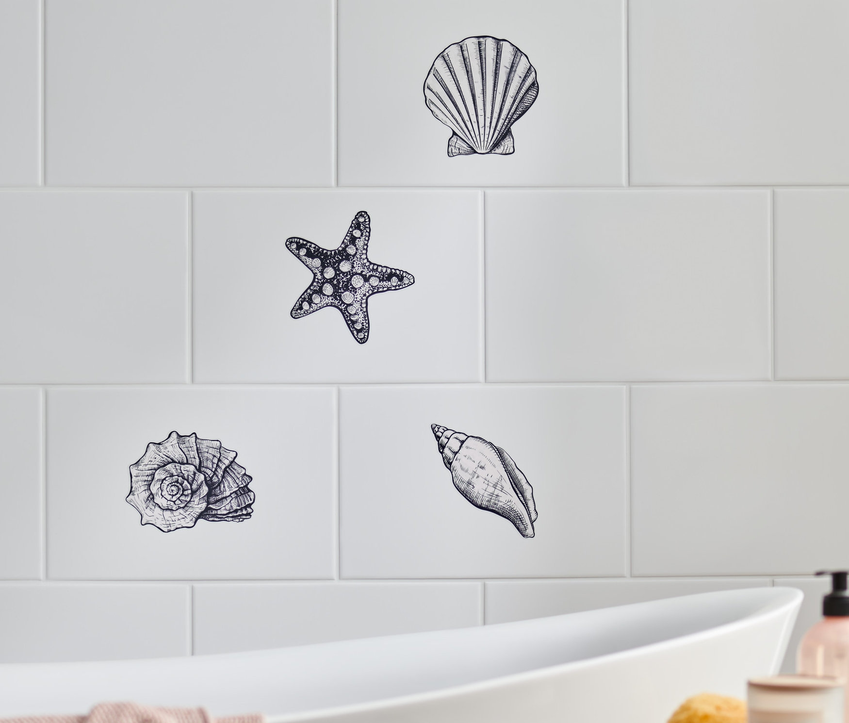 Beyaz fayanslar üzerinde deniz temalı fayans çıkartmaları, deniz kabukları ve deniz yıldızları.