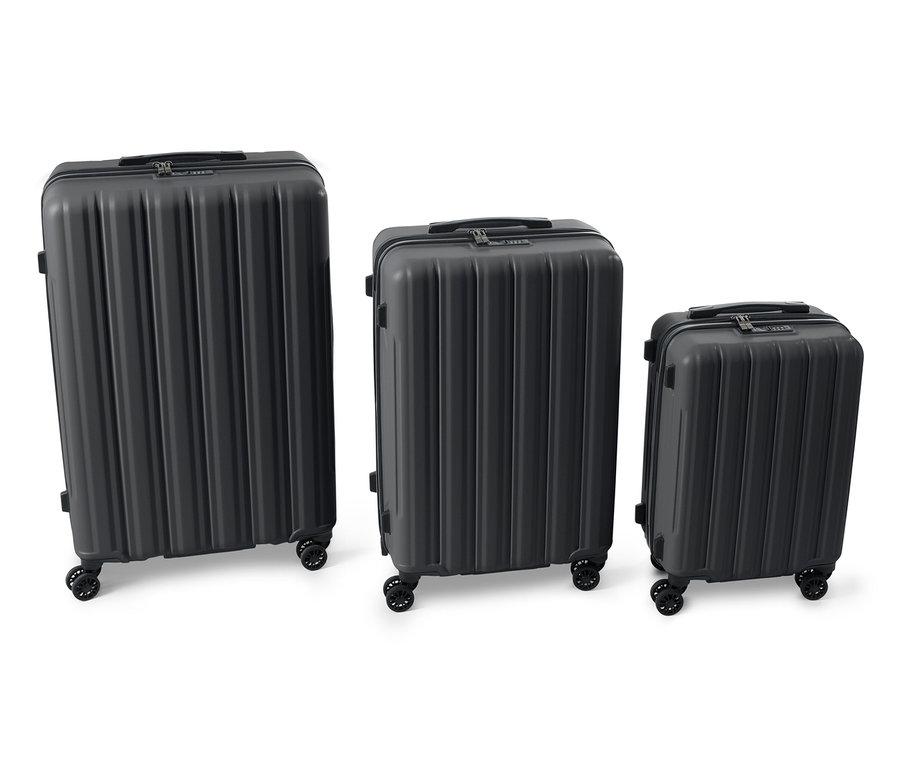 Yan yana duran, farklı boyutlarda üç adet siyah sert bavul.