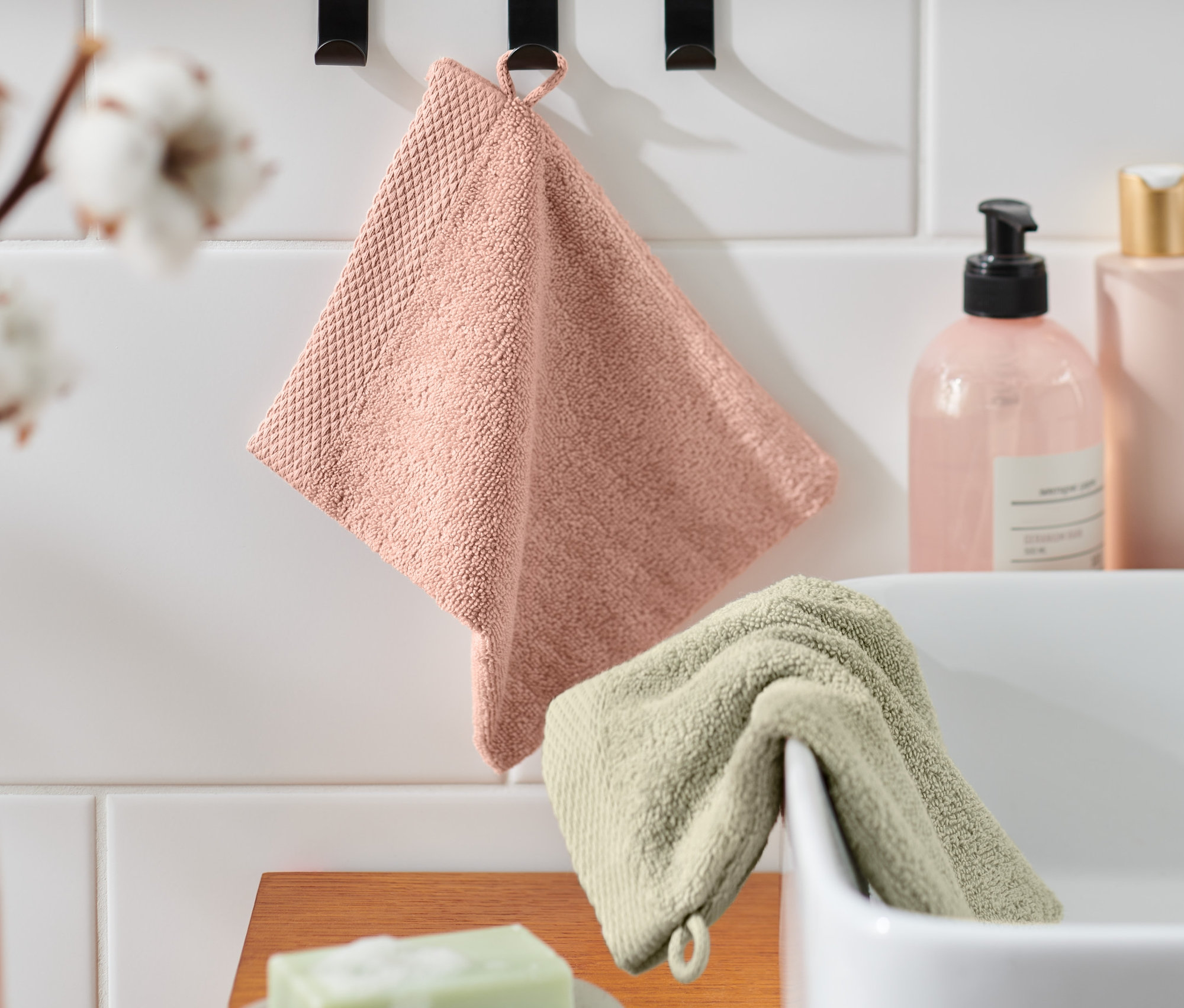 Banyoda asılı duran iki adet yüksek kaliteli kese, biri pembe diğeri yeşil.