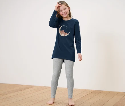Gülümseyen kız çocuğu Çocuk Pijama Takımı içinde poz veriyor.
