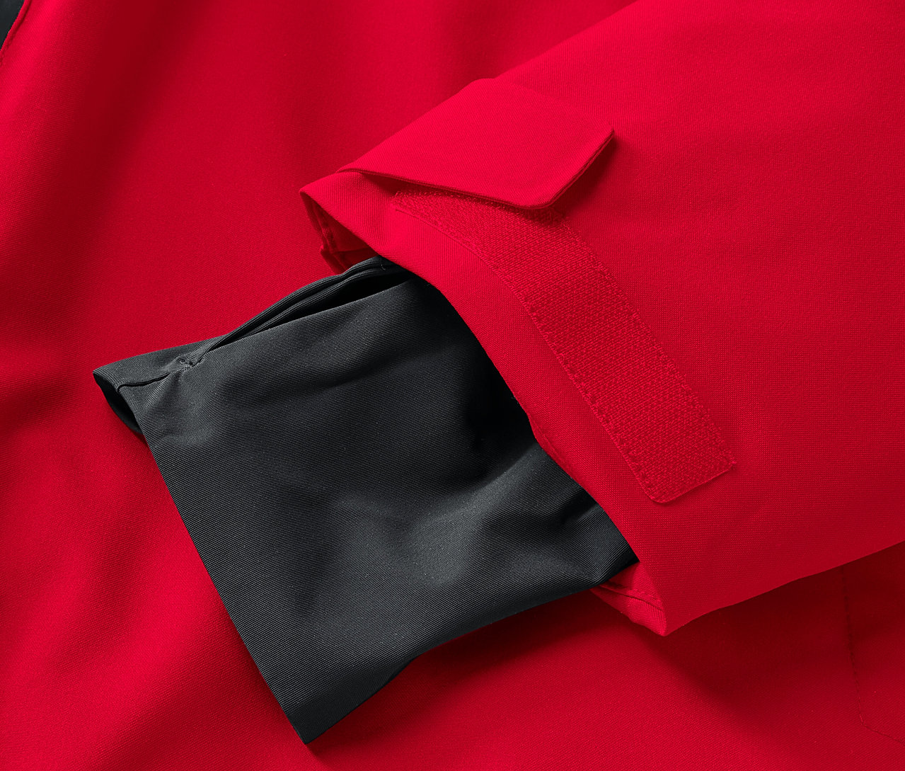 Kolunda siyah iç cebi olan kırmızı bir ceket detayı.