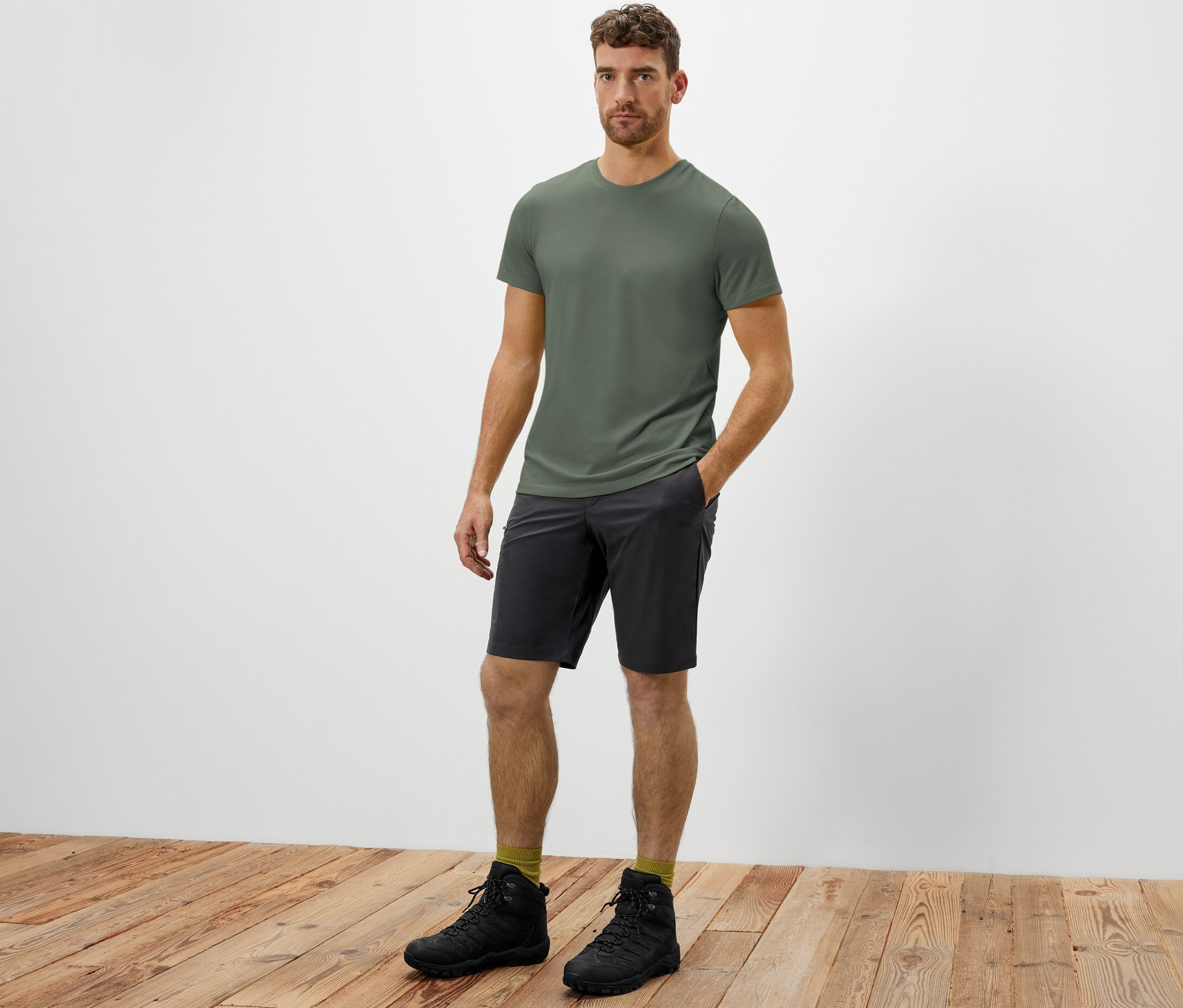 Adam softshell fonksiyonel şortun cebinde eliyle ayakta duruyor.