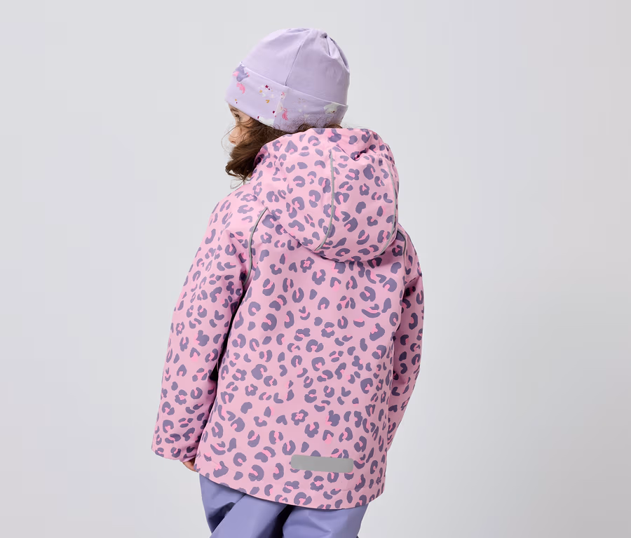 Gri bir arka plan önünde leopar desenli pembe bir ceket ve mor bir şapka giyen bir çocuğun arka görünümü.