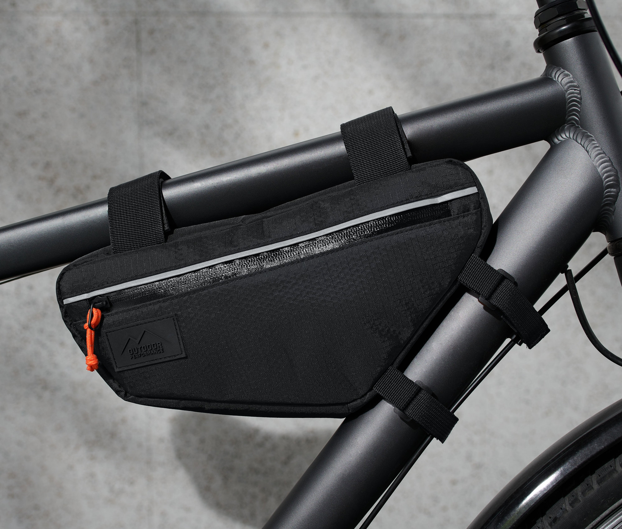 Bisikletin çerçevesine takılmış siyah bir gidon çantası.