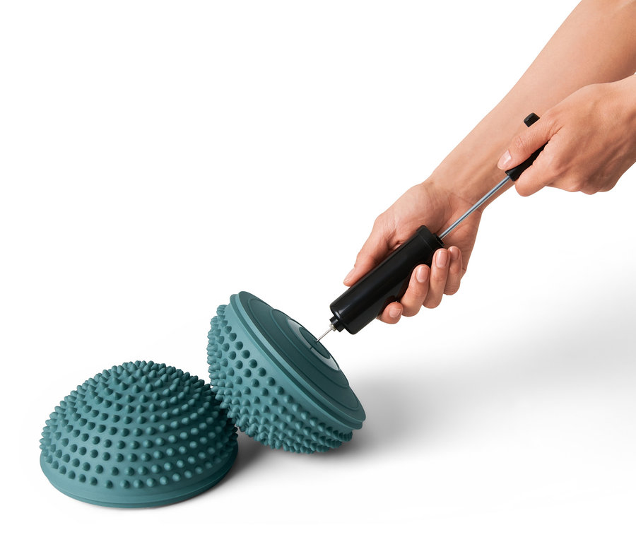 Bir kişi 2'li setten bir denge pedini pompa ile şişiriyor.