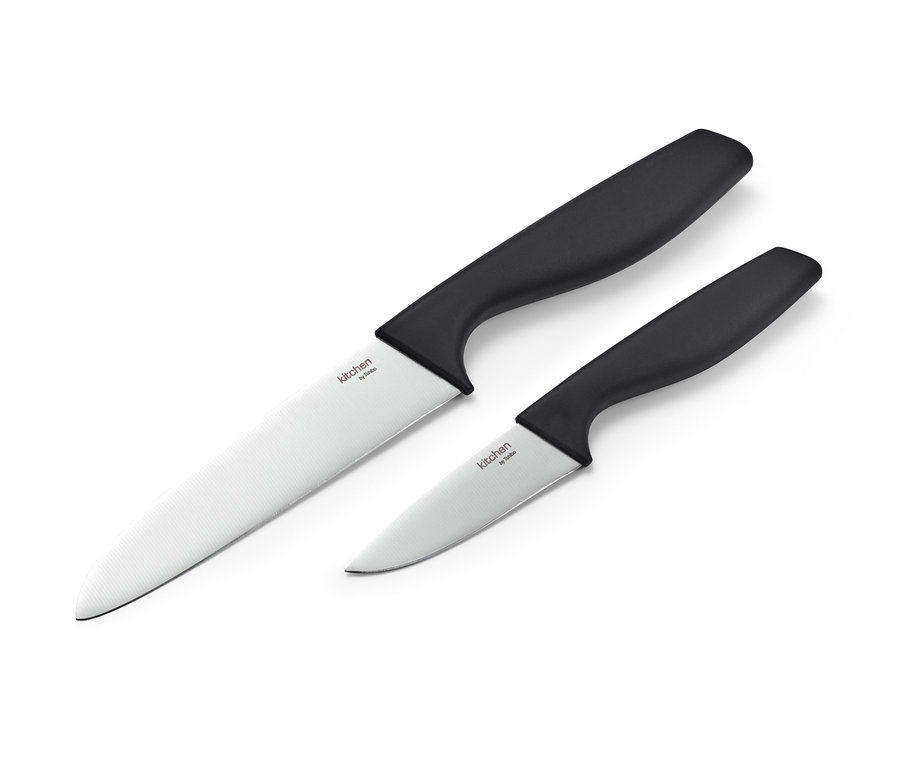 Siyah saplı mutfak bıçağı setinden iki mutfak bıçağı beyaz bir arka plan üzerinde duruyor.