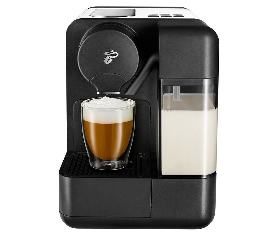 Siyah kahve makinesi, beyaz Cafissimo sütü ve kahve dolu bir bardak.