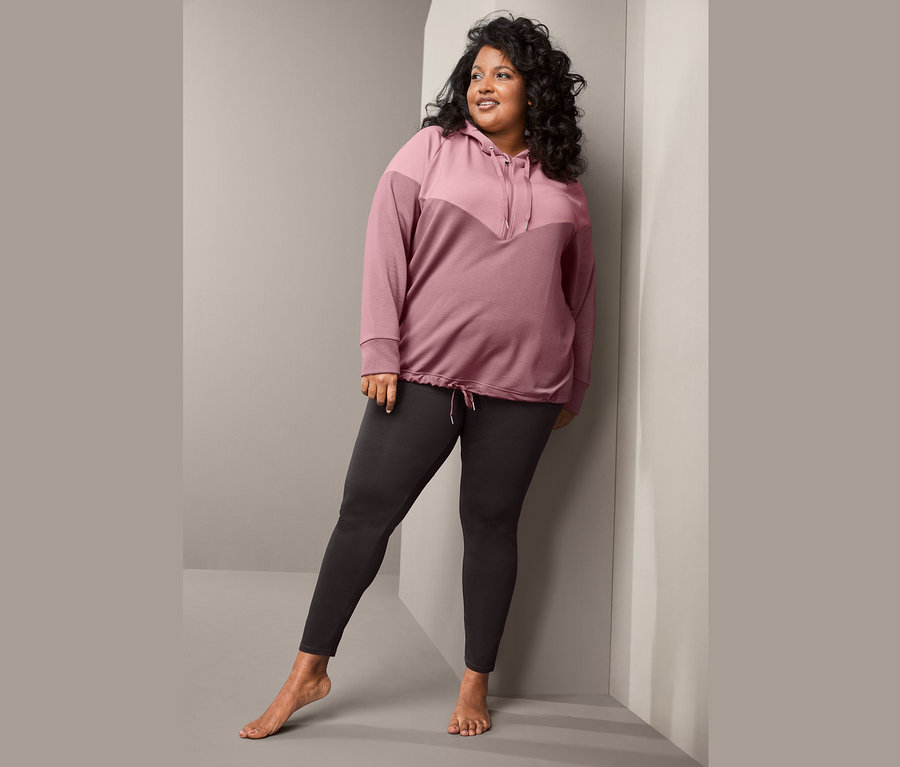 Kadın Eşofman Üstü ve Organik Pamuklu Spor Taytı ile poz veriyor.