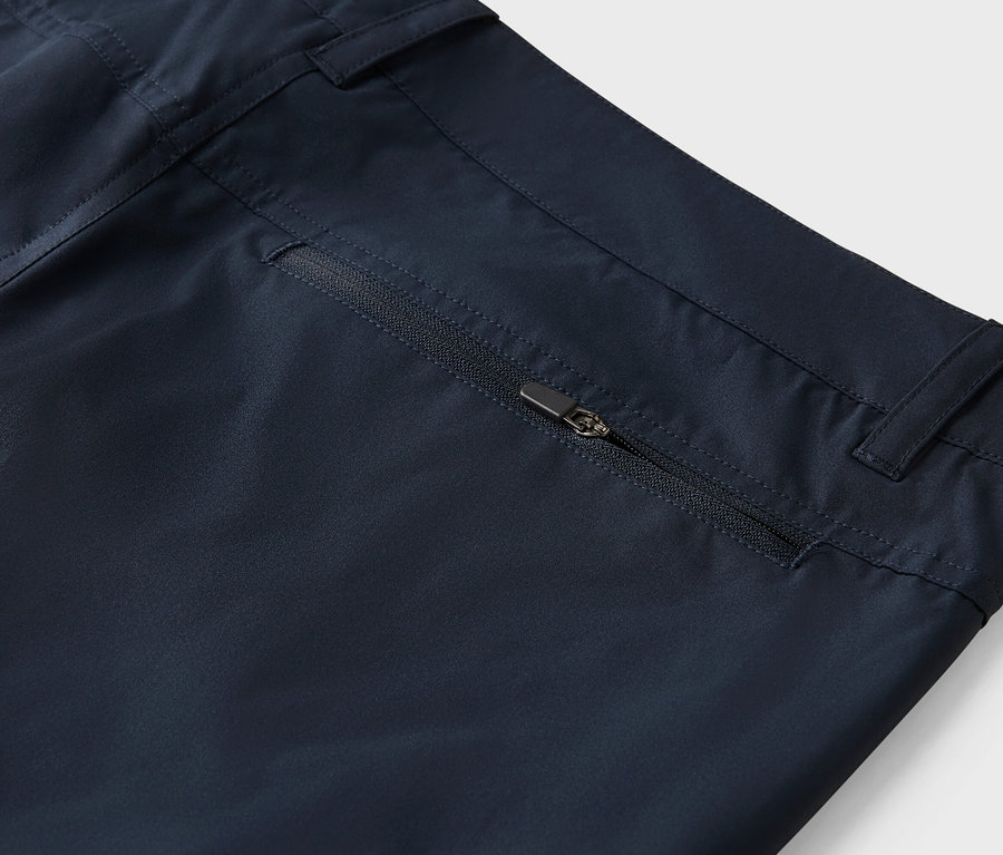 Fermuarlı cepli lacivert pantolonun yakın çekim görüntüsü.