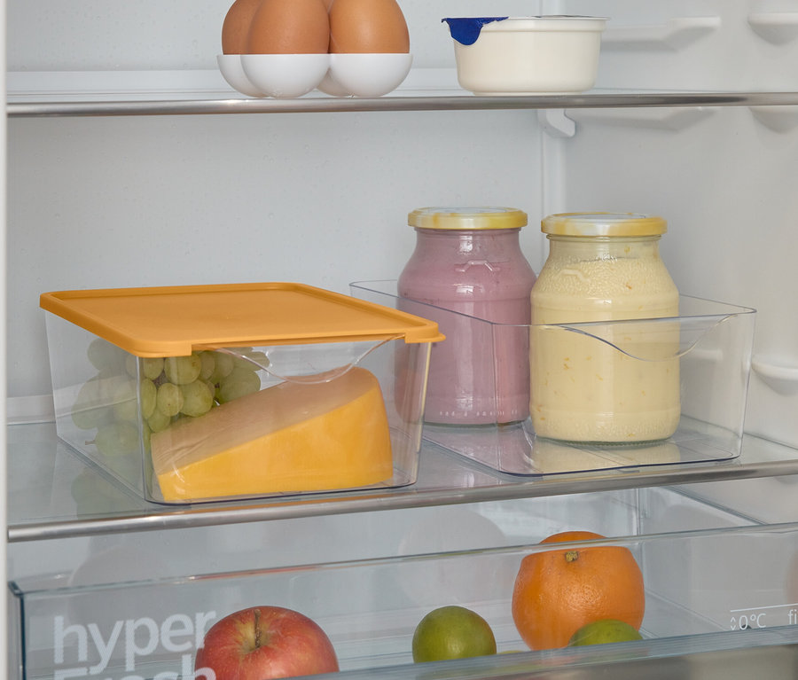 İçinde yiyecek olan bir buzdolabının görüntüsü. Üstte yumurtalar, altta reçel kavanozları, şeffaf bir kapta peynir ve üzüm var.