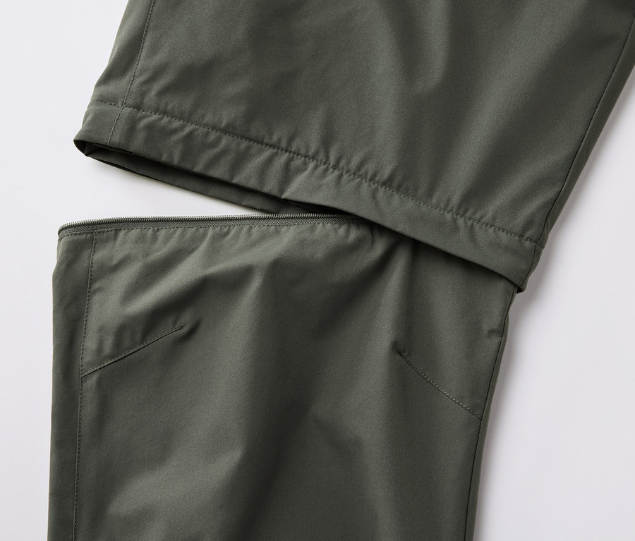 Fermuarlı, haki renkli 2'si 1 arada fonksiyonel pantolonun yakın çekimi.