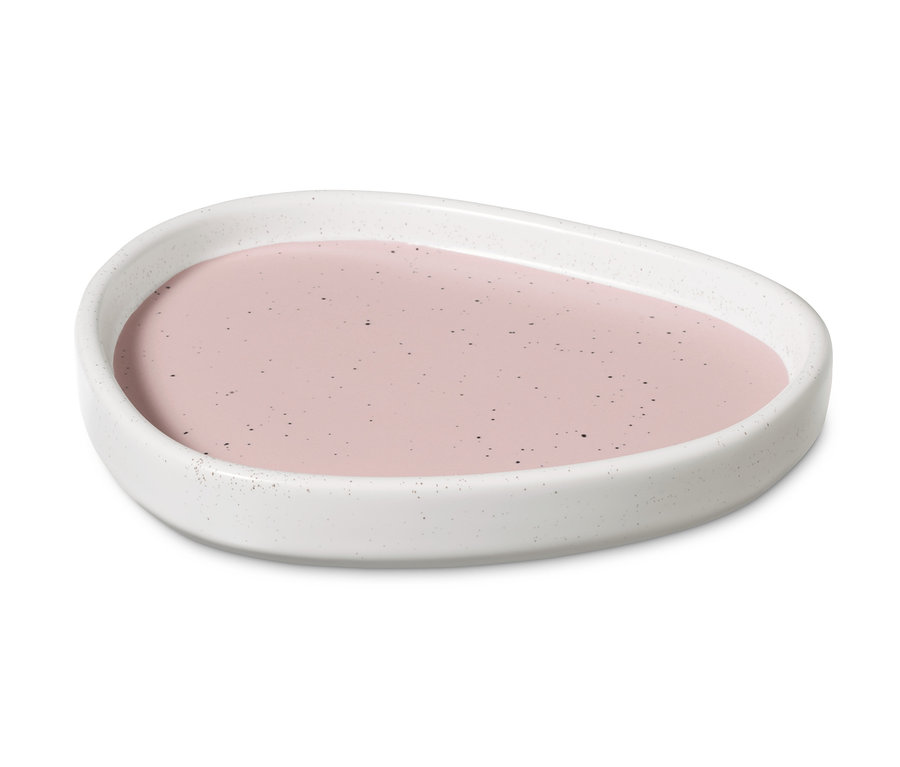 Ortasında pembe sıvı bulunan seramik tepsi.