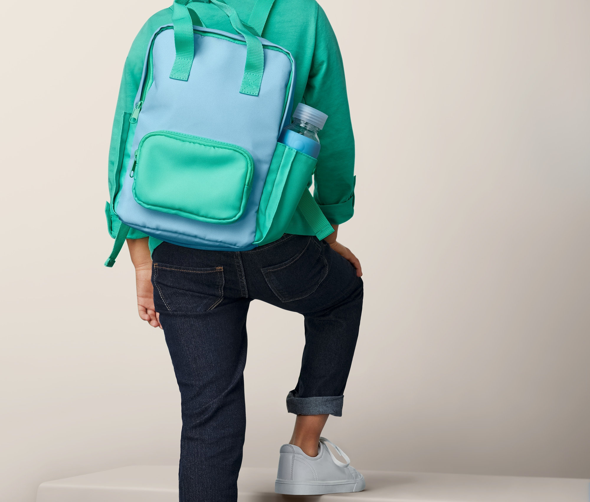 Merdivenleri çıkan, sırtında Mini Outdoor Sırt Çantası olan erkek çocuk.