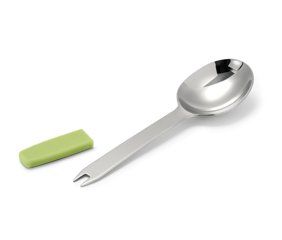 Beyaz bir arka plan üzerinde gümüş bir kaşık ve yeşil bir kılıf.